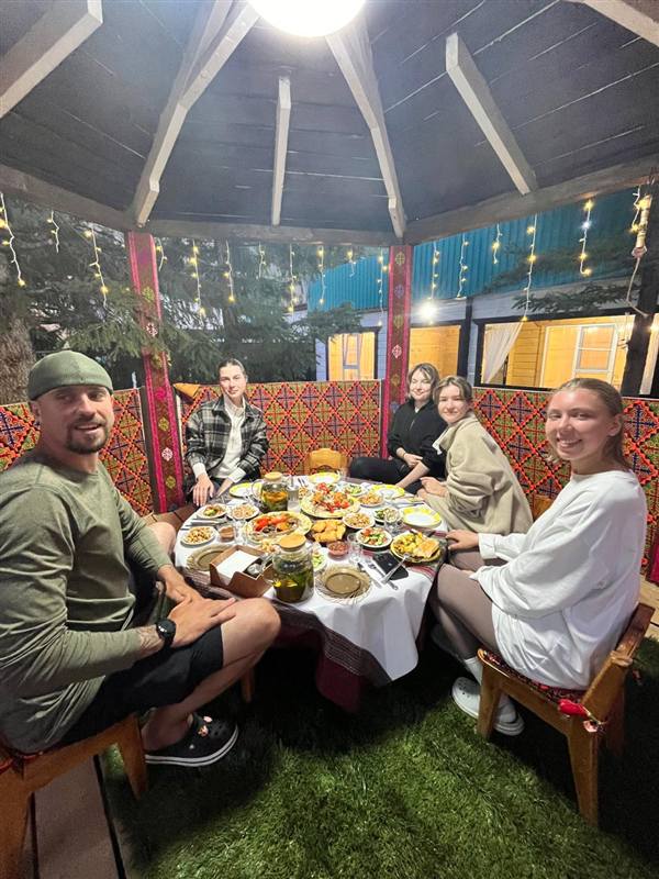 Гости за общим столом в беседке
